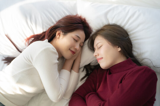 Portrait of couple lesbian in bed room. They sleeping together in bedroom with smiling.