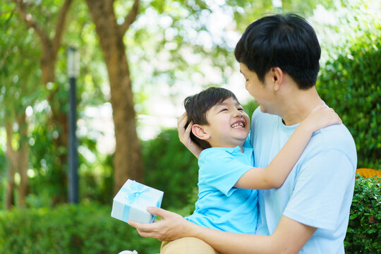 Lovely Asian little young boy giving his daddy the greeting card for the international father's day, lovely boy gives his father a drawing DIY Father's Day greeting card.
