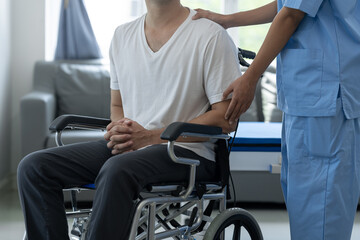 Fototapeta na wymiar Rehabilitation specialist or physiotherapist giving physical training instruction to male patient in wheelchair at rehabilitation center The concept of physical therapy and health insurance.