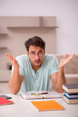 Young male student preparing for exams at home