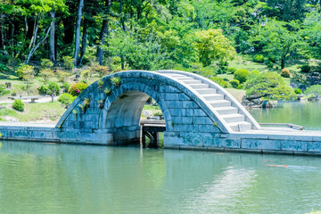 Concrete bridge over man made lake in Shukkeien gardens in Hiroshima.