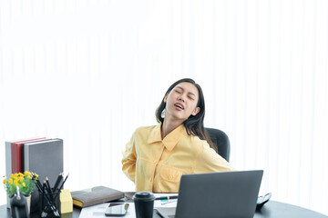 Office syndrome concept. Young asian businesswoman feeling pain in neck after working on computer laptop for a long time