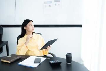 Young asian woman confident working at office with laptop computer and thinking idea for planning, freelance happy girl excited and success using notebook thoughtful and writing, business concept.