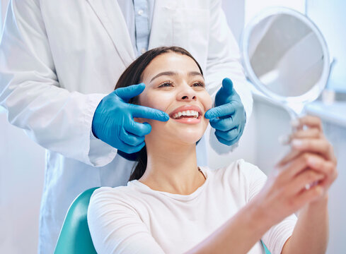 Dental consultation, mirror and woman with smile after teeth whitening, service or mouth care. Healthcare, dentistry and happy female patient with orthodontist for oral hygiene, wellness and cleaning