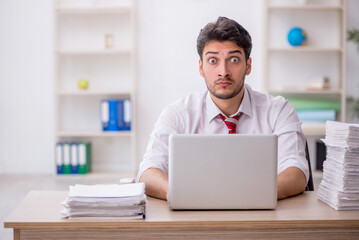 Young male employee and too much work in the office