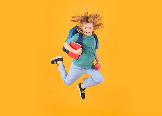 Fototapeta na wymiar Back to school. Full length body of cheerful school child jumping running back to school isolated over yellow background.
