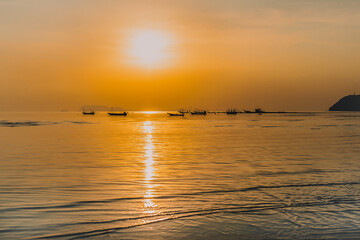 Silhouette of fishing boats at sunset in the sea.