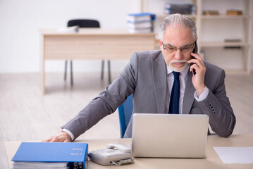 Old male employee working in the office