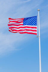 american flag waving in the wind on blue sky