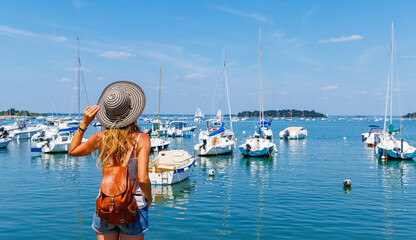 Travel in Brittany,  woman tourist looking at atlantic ocean and boats, port- Morbihan in France