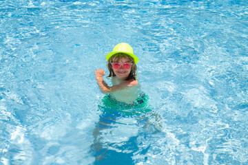 Fototapeta na wymiar Child boy in swimming pool on summer vacation. Beach sea and water fun with children.