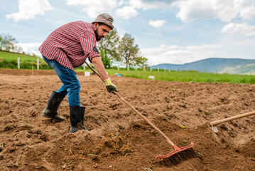 Male farmer working on an agricultural fields in spring.