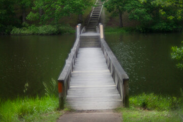 Footbridge across the water with stairway soft focus for mystery, dream or adventure