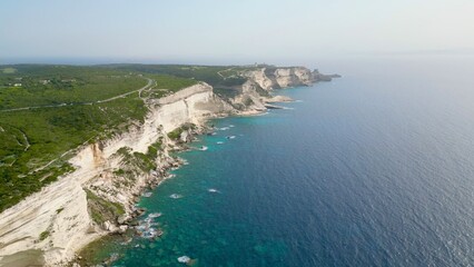 Fototapeta na wymiar The Imposing Sentinel: Fog-Clad Cliffs and Azure Sea of Bonifacio Coast, Corsica, Guarded by Pertusato semaphore