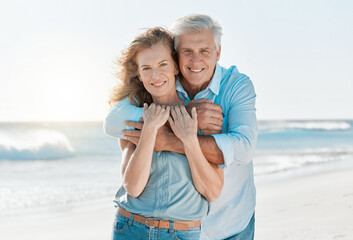 Fototapeta na wymiar Senior, couple and portrait hug at the beach for happiness and bond in the outdoor. Mature, man and woman holding one another at the ocean with smile and love for vacation and travel in summer