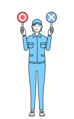 正解と不正解を示す棒を持つ帽子と作業着姿のシニア女性（経営者、管理職、上司）