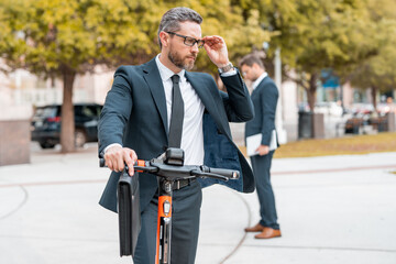 Scooter allows business man in suit to be efficient and punctual. Electric scooter provides a quick...