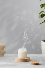 White interior candle in glass with smoke from the wick. Handmade candle. Hugge