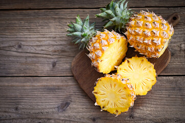 Obraz na płótnie Canvas fresh pineapple tropical fruits summer, pineapple slice on plate for food fruit ripe pineapple on wooden background - top view