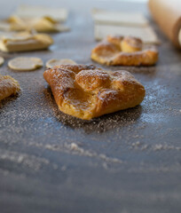 Puff pastry fresh baked with sour cream filling on a table with unbaked dough