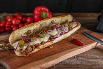 Submarine sandwich with pulled turkey meat, cheese, pickles, oniones and barbecue sauce
