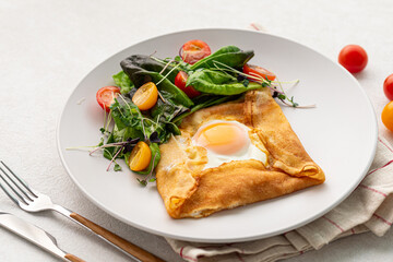 Portion of gourmet breakfast with fried egg in a pancake 