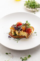 Gourmet breakfast bruschetta with scrambled egg and vegetables