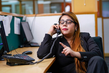 Female customer support operator talking on telephone at office