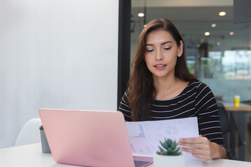 beautiful businesswoman reading analysis report working typing laptop. young female professional business manager corporate.