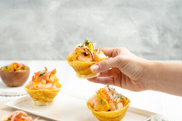 Hand holding delicious shrimps basket