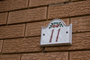 House number plaque on brick wall