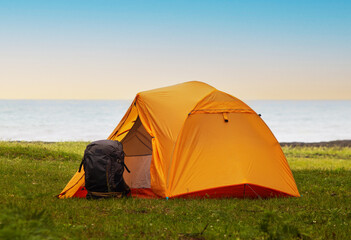 Camping tent on the grass by the sea. Camping concept.