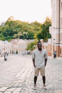 Young smiling african man is standing among street.