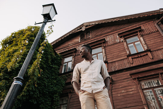 Young waiting african man is standing on street in city.