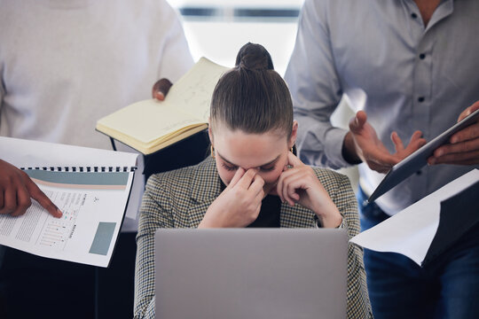 Laptop, stress and multitask with a business woman and demanding colleagues working in the office. Headache, anxiety and deadline pressure with an overwhelmed female employee at work on a computer