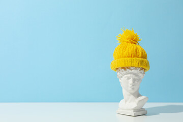 Ancient head in hat against blue background