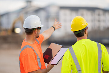 Worker pointing out. Construction worker with hardhat helmet on construction site. Engineer worker in builder uniform. Portrait of builder ready to build new house.