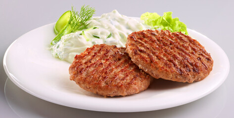 Frikadellen mit Quark und Gurke auf weissem Porzellanteller