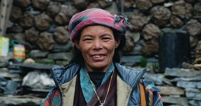 Warmth of rural Nepal as a smiling rural woman welcomes you to the picturesque Tsum Valley at Manaslu Trekking. Immerse yourself in the beauty of the Himalayas in this captivating stock footage.