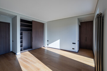 empty apartment without furniture and an empty open closet against the wall