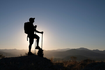 silhouette of successful mountaineer on top of mountains