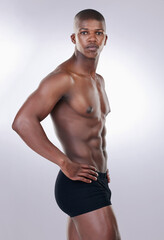 Fototapeta na wymiar Attractive, confidence and portrait of a shirtless man in a studio with a muscular body in underwear. Serious, fitness and young African male model with a strong and sexy figure by white background.
