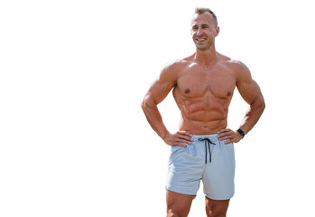Strong young adult caucasian man in sportswear shorts stands against transparent background. Cheerful bodybuilder smiles looks away.