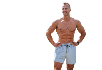 Strong young adult caucasian man in sportswear shorts stands against transparent background. Cheerful bodybuilder smiles looks away.