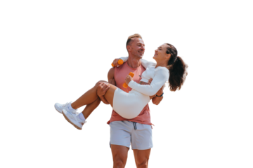 Cheerful caucasian young man carrying young wife wearing sportswear against transparent background. Sport, fitness, healthy lifestyle.
