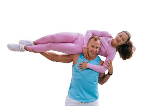Young adult cheerful caucasian man in sportswear carrying sporty brunette woman on shoulders against transparent background. Happy couple training with wife. Healthy lifestyle.