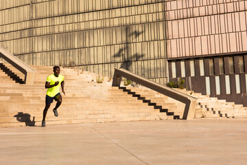 Fitness training outdoors. Handsome African man running. Muscular man training.