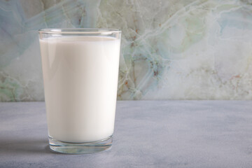 A glass of milk on a blue table on a marble background,copy space