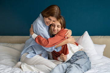 Caring European mother hugging teenage girl. Pleased mom and teen daughter feel grateful thankful,...