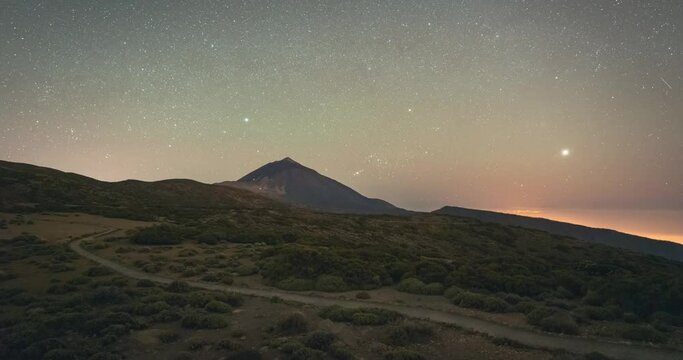 Timelapse of volcano Teide during the night against starry sky and Orion constellation.